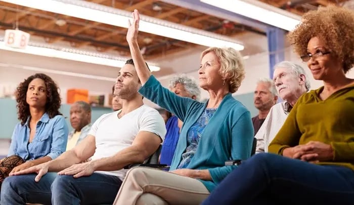 Homeowners attending a community association meeting, raising questions and participating in decisions—showcasing how ManageCasa supports transparent HOA governance