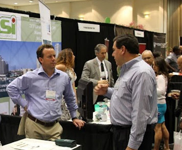 Community association professionals speaking with vendors at a Palm Beach Condo & HOA Expo booth
