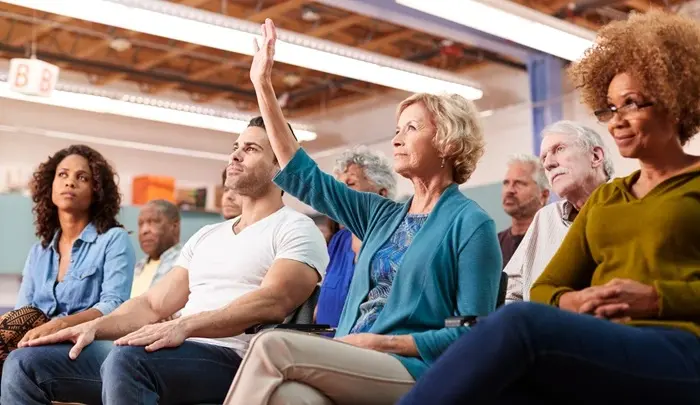 HOA members engaging in an electronic voting discussion during a community meeting
